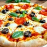 Freshly baked classic pizza with mozzarella cheese and colorful toppings on a wooden board.