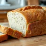 Freshly baked loaf of sandwich bread on a wooden table.