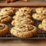 A batch of freshly baked Carrot Cake Cookies cooling on a wire rack, showcasing their golden edges and soft texture.