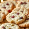 A beautifully arranged platter of freshly baked Cranberry Pistachio Shortbread Cookies, with some cookies dipped in white chocolate and others decorated with pistachios and cranberries.