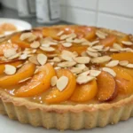 Tarte moelleuse aux abricots et amandes sur table en bois, dessert français doré et moelleux