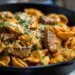 Creamy paprika steak shells pasta in cast iron skillet with tender beef pieces, rich cream sauce, and fresh parsley garnish
